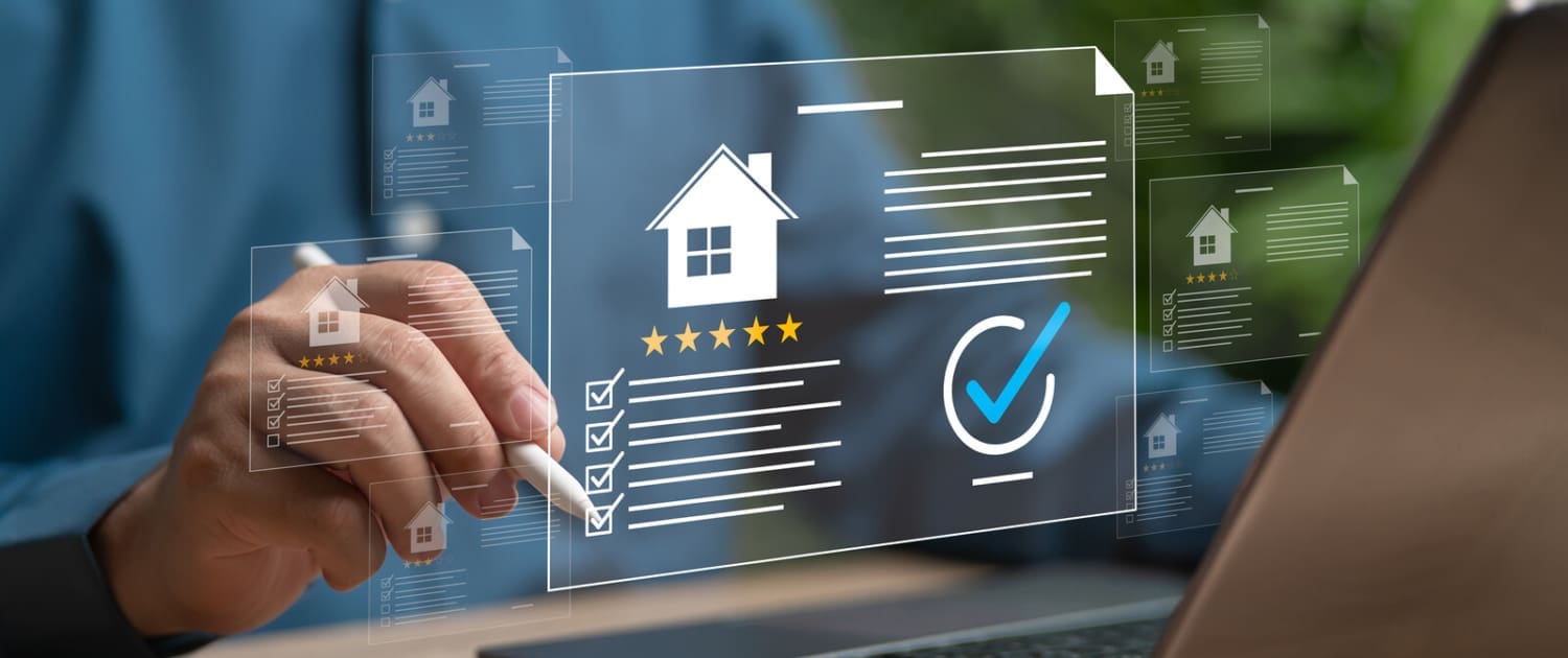 Property Valuations Brisbane Online, A person uses a stylus and laptop to interact with virtual real estate icons, such as a house and checklist, on a transparent screen interface—perfect for exploring Property Valuations Brisbane Online. A smartphone rests on the wooden desk nearby.