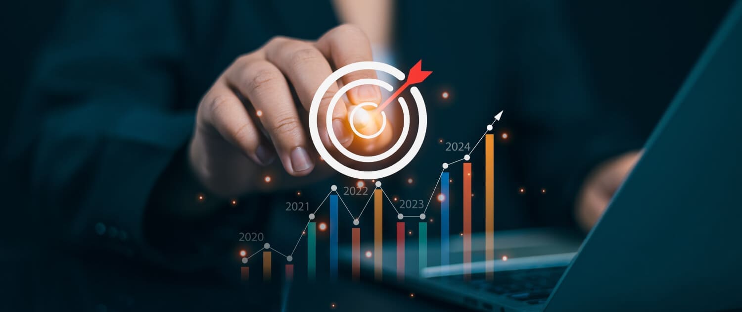 A person in business attire touches a digital target graphic with a dart in the bullseye, overlaid with a bar chart showing growth from 2020 to 2024, symbolizing Business Valuations Mackay and goal achievement.